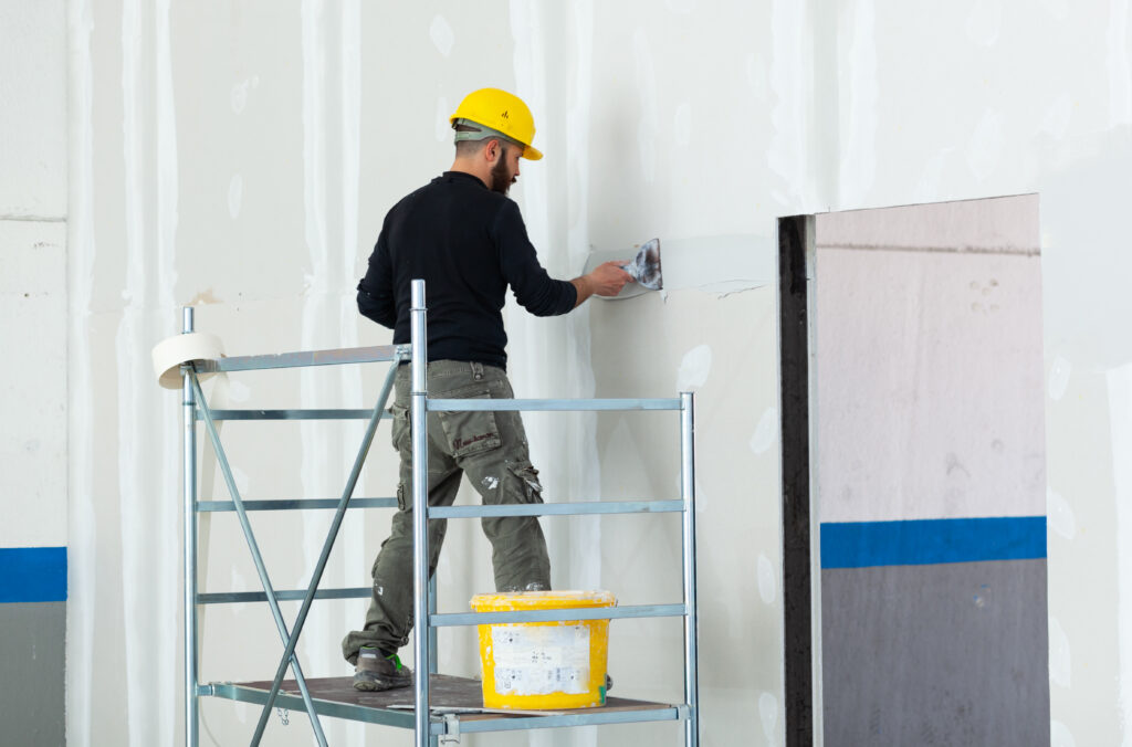 Arbeiter beim Verputzen einer Gipskartonwand - Trockenbau